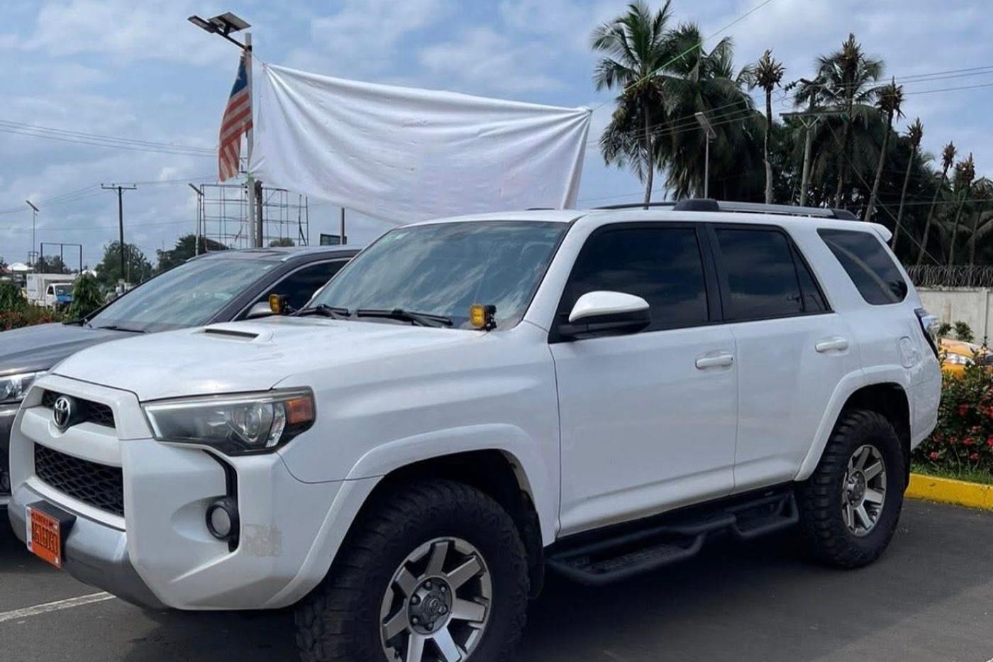 White Toyota 4Runner with off road tyres parked in daylight, front three quarter view