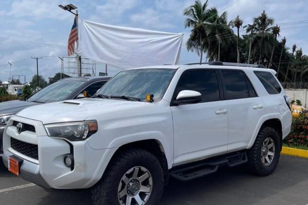 White Toyota 4Runner with off road tyres parked in daylight, front three quarter view