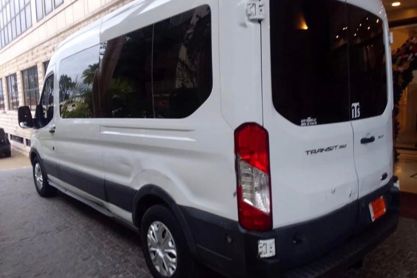 White Ford Transit passenger van parked outside a hotel entrance in Monrovia